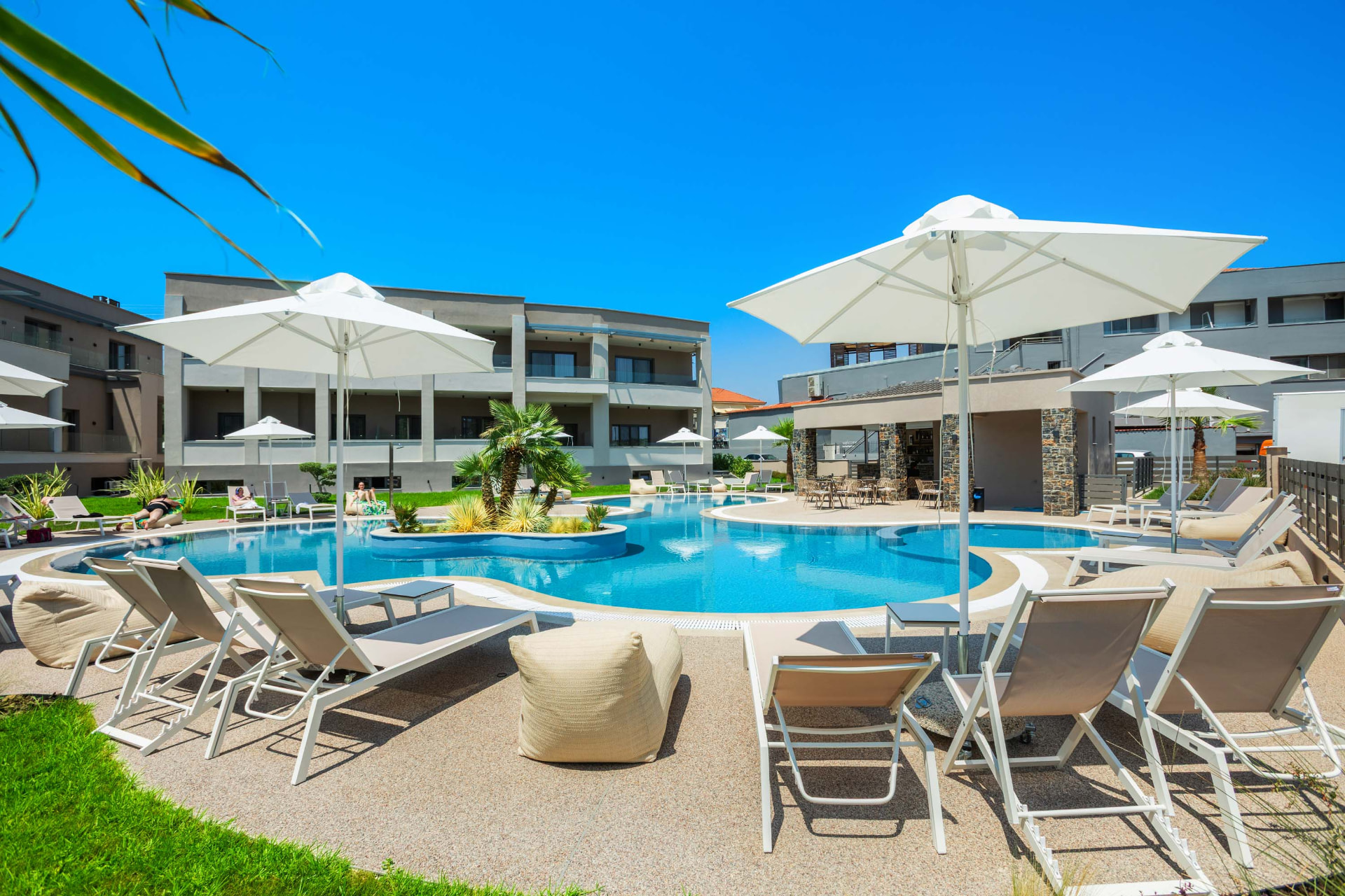 anese pool with sunbeds and umbrellas